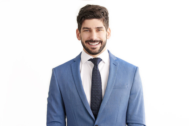 Portrait of smiling young professional businessman wearing suit and tie and smiling while standing at isolated white background.  - Foto, immagini