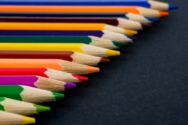 Color pencils on black background close up. - Foto, Bild