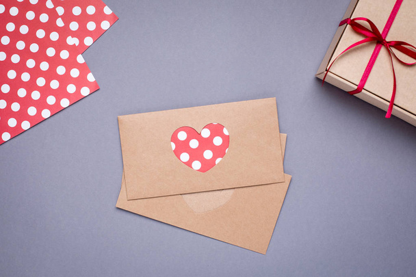 Top kalp kartı ve hediye kutusunda gri arka plan üzerinde saten kurdele ile görünüm - Fotoğraf, Görsel