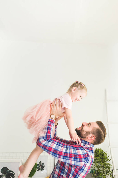 Cute little girl and her dad are having fun at home. - Foto, afbeelding