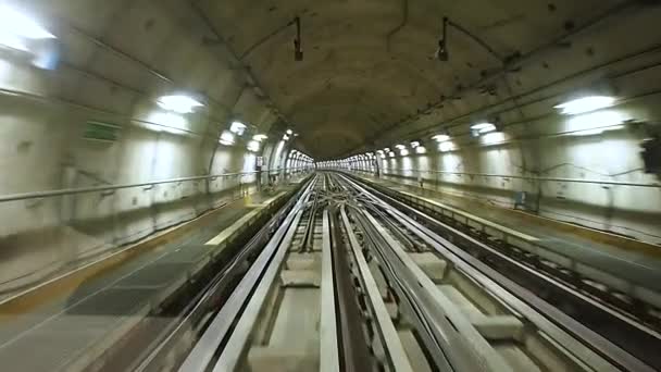 Perspektivischer Blick auf U-Bahn-Tunnel und Gleise vom fahrenden Zug aus, mit schimmernden Neonlichtern - Filmmaterial, Video