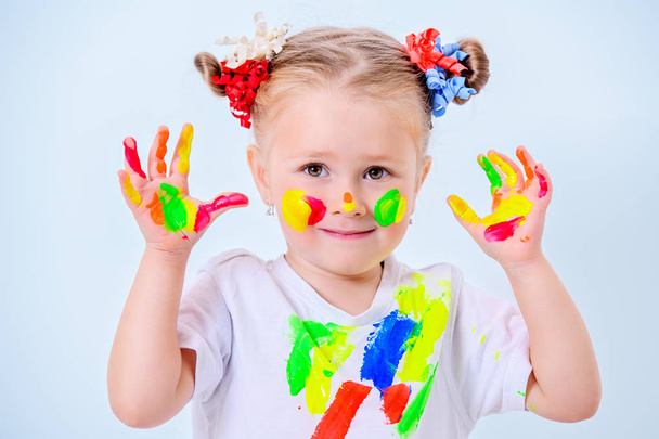 Egy aranyos lány, színes festékek a portréja. Gyermekkori, szabadidős tevékenységek. - Fotó, kép