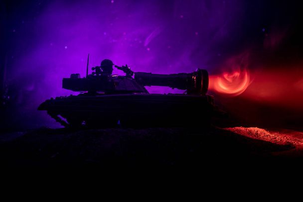 War Concept. Armored Tank Silhouette Below foggy fire sky at night. Attack scene. Toy decoration. Selective focus - Φωτογραφία, εικόνα