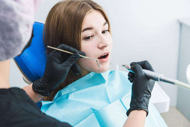 Dental clinic. Reception, examination of the patient. Teeth care. Dentist curing a girl patient - Φωτογραφία, εικόνα