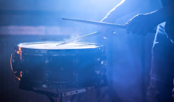 ο άνθρωπος που παίζει το snare drum για ένα όμορφο έγχρωμο φόντο, η έννοια των μουσικών οργάνων - Φωτογραφία, εικόνα