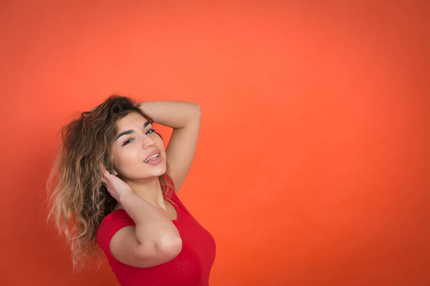 positive girl on a red background in a red t-shirt - Foto, Imagen