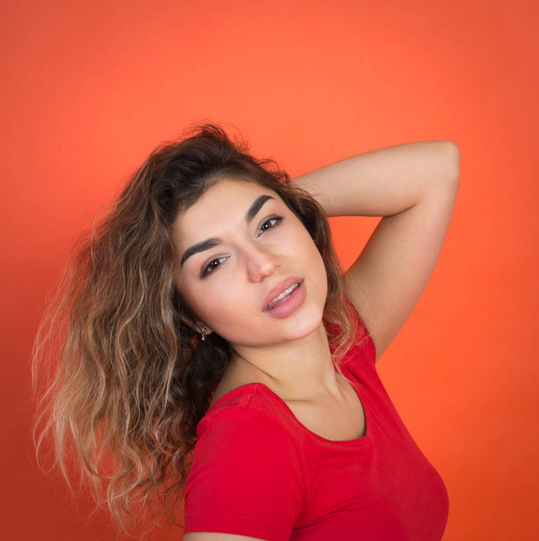 positive girl on a red background in a red t-shirt - Foto, Bild