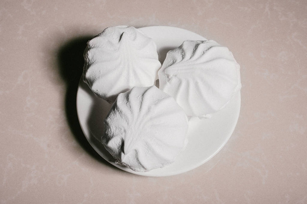 Three delicious sweet dessert white marshmallows zephyr on a saucer close-up. Copy space - Fotó, kép