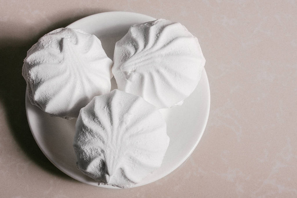 drei köstliche süße Dessert weißen Marshmallows Zephyr auf einer Untertasse Nahaufnahme. Kopierraum - Foto, Bild