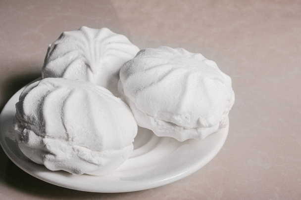 Drie heerlijke zoete dessert witte marshmallows zephyr op een schotel close-up. Kopiëren van ruimte - Foto, afbeelding
