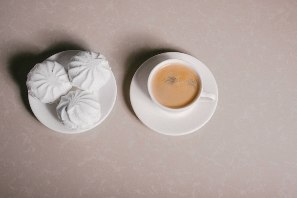eine Tasse frischen Kaffee, American und drei köstliche süße Dessert weißen Marshmallows auf einer Untertasse Nahaufnahme. Kopierraum - Foto, Bild