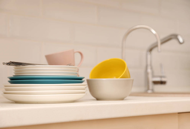 Clean dishware and cutlery on counter near kitchen sink - Φωτογραφία, εικόνα