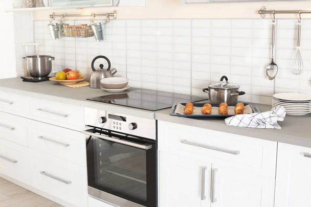 Elegante cocina interior con horno moderno y juego de utensilios de cocina
 - Foto, Imagen