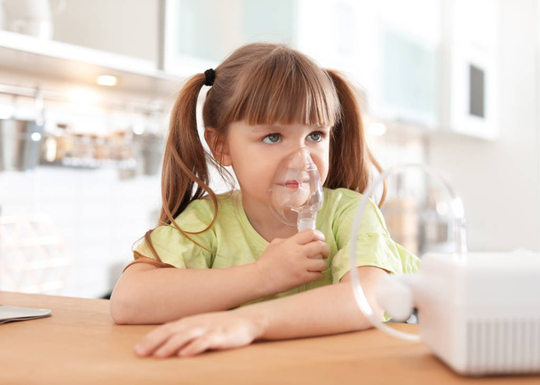 Little girl using asthma machine at table in kitchen - Fotoğraf, Görsel