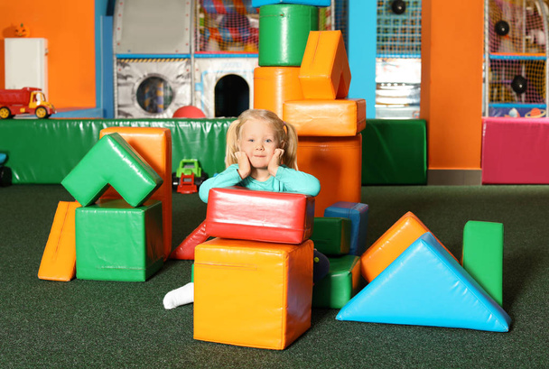 Cute child playing with colorful building blocks indoors - Фото, изображение