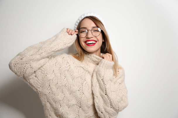 Beautiful young woman in warm sweater with hat on white background - Фото, зображення