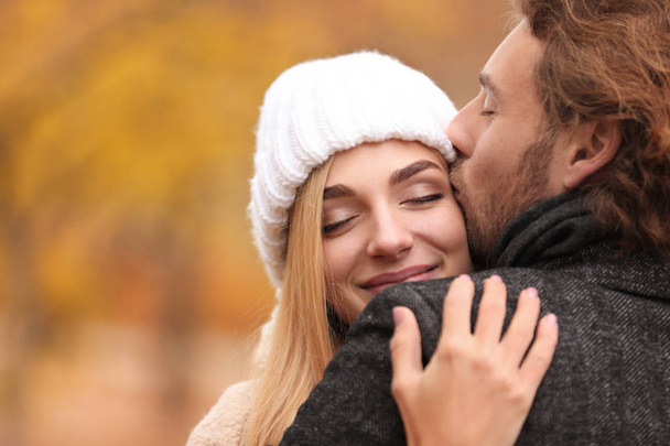 Young romantic couple hugging outdoors on autumn day - Fotó, kép