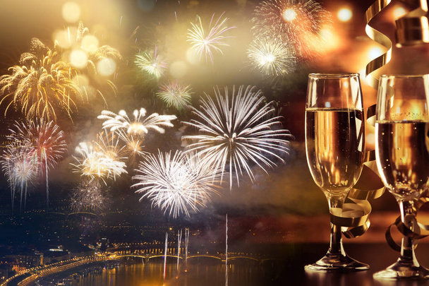 kaksi samppanjalasia nauhoilla lomavaloja ja ilotulitteita vastaan - uudenvuoden juhlat
 - Valokuva, kuva