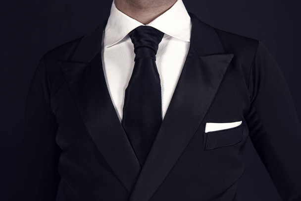 Mies mustassa smokissa ja valkoisessa paidassa
 - Valokuva, kuva