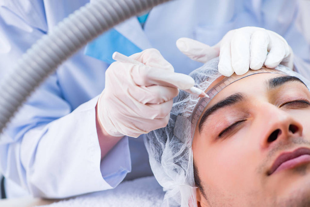 A plasztikai műtét előtt a betegek arcát mérő orvos - Fotó, kép