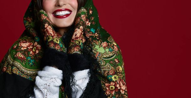 Portrait of High fashion glamour beautiful brunette hair Russian style woman in traditional scarf and gloves on red  - Zdjęcie, obraz