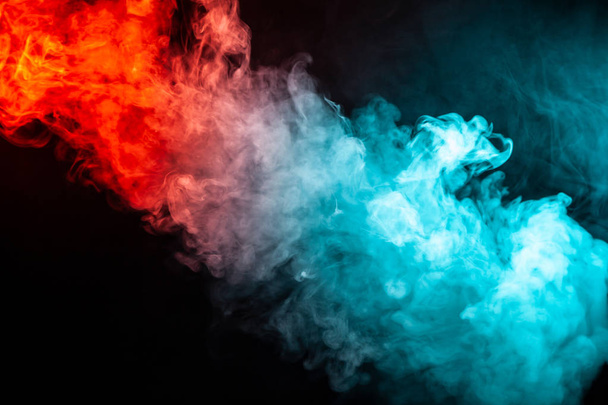 Колонна цветного дыма зеленого и красного цвета из чашечки абстрактной формы, которая тянется вверх на черном изолированном фоне
. - Фото, изображение