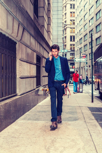 Європейська бізнесмен подорожі в Нью-Йорку. Молодий хлопець з бородою, проходячи через переповненому високі будівлі вулиці, дивлячись, говорити на своєму мобільному телефоні. Ходьба не самотній. Технології в повсякденному житті. - Фото, зображення