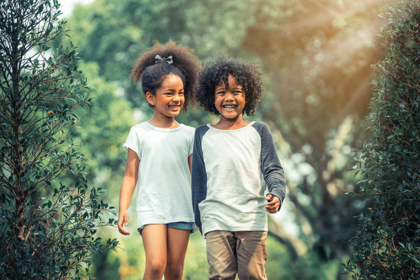 Menino e menina felizes no parque. Duas crianças afro-americanas juntas no jardim
. - Foto, Imagem