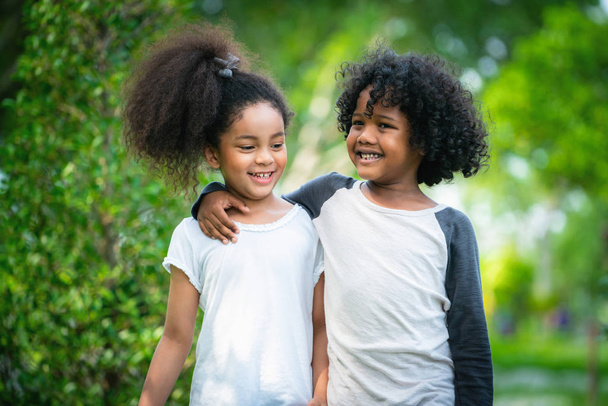 Happy little boy and girl in the park. Two African American children together in the garden. - Fotografie, Obrázek