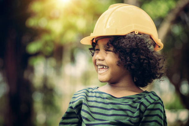 Happy little boy engineer wearing yellow safety helmet hard hat and laughing with happiness. Education and learning concept. - Foto, Imagem