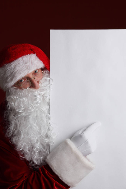 Santa Claus sosteniendo cartelera de papel blanco con espacio de copia para texto - Foto, Imagen