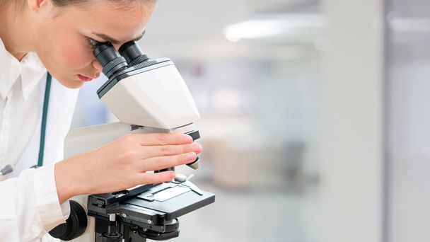 Επιστήμονας ερευνητής χρησιμοποιώντας μικροσκόπιο στο εργαστήριο. Ιατρικής τεχνολογίας υγειονομικής περίθαλψης και φαρμακευτικής έρευνας και ανάπτυξης έννοια. - Φωτογραφία, εικόνα