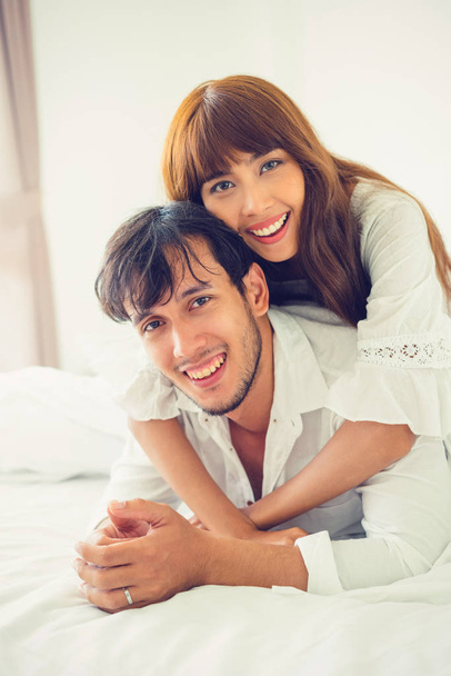 Happy young couple relaxing in home bedroom after waking up in the morning. - Photo, Image