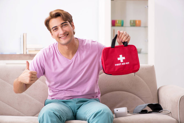 Hombre enfermo en casa con botiquín de primeros auxilios
 - Foto, Imagen