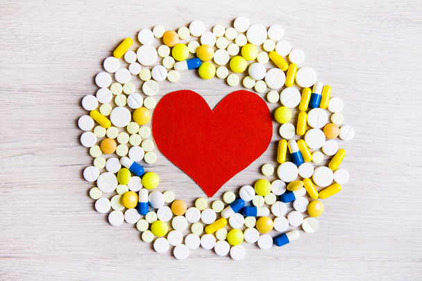 Red Heart Shape with a Pills on the Table closeup - Foto, Imagen