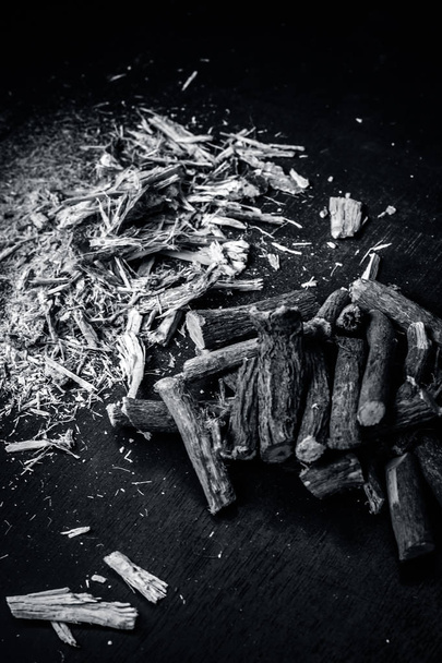 Ayurvedic licorice roots and chips on dark wooden table - Φωτογραφία, εικόνα