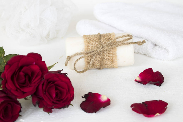 Kräuterseife, Frottee Gesundheitspflege für die Körperhaut mit Blume Rose auf weißem Holz Hintergrund - Foto, Bild