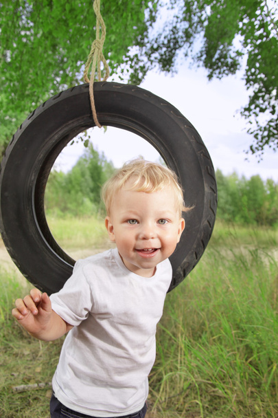 happy boy on swing outdoors - Fotoğraf, Görsel
