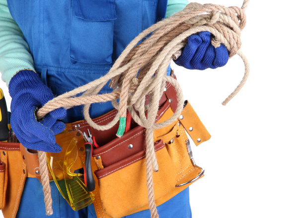 Мужчина-строитель в синем комбинезоне с веревкой, изолированной на белом
 - Фото, изображение