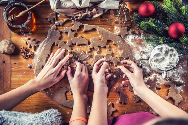 Gingerbread dough and young girls hands preparing christmas biscuit cakes. - Fotó, kép
