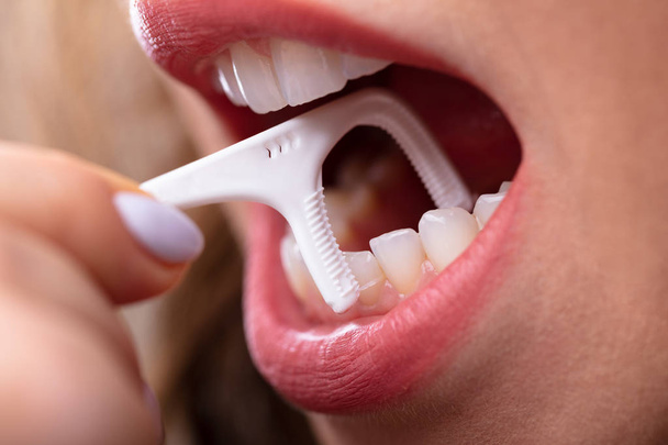 Close-up Of A Woman's Hand Cleaning Teeth With Dental Floss - Φωτογραφία, εικόνα
