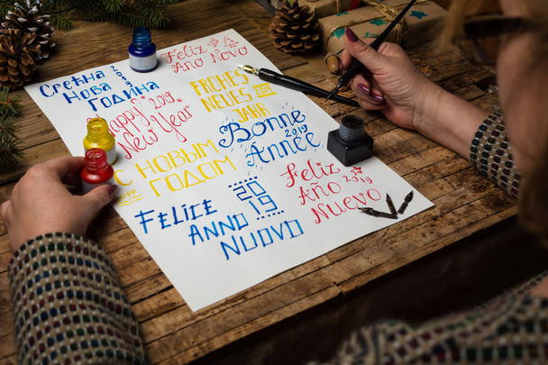 Boldog új évet írásban sok különböző nyelveken kalligráfia nő - Fotó, kép