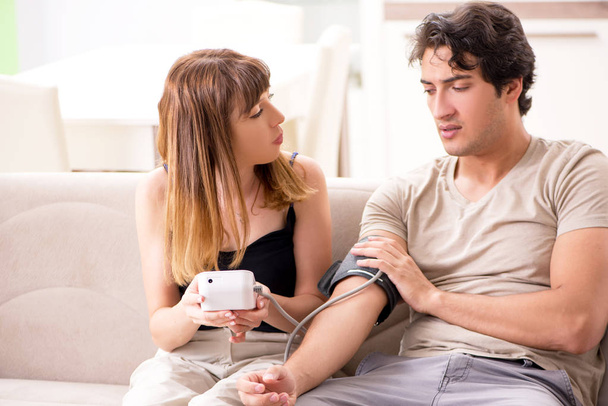 Mulher verificando maridos pressão arterial
  - Foto, Imagem