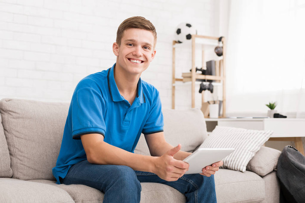Teen guy using digital tablet at home - Zdjęcie, obraz