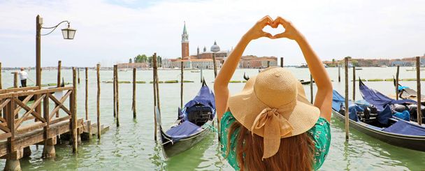 Woman making heart shape with hands on beautiful view of Venice. Panoramic banner view with Venice Lagoon. - Photo, Image