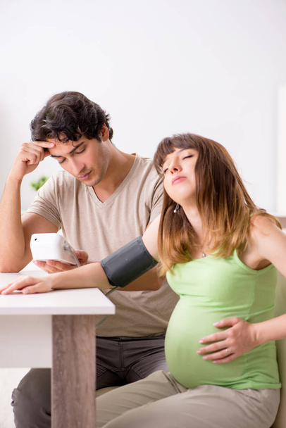Муж проверяет давление беременных жен
 - Фото, изображение