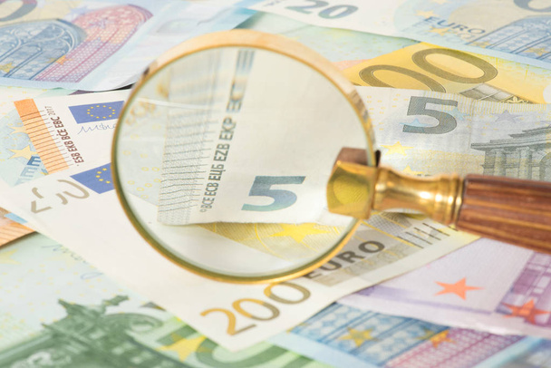 Euro bills and a magnifying glass - Photo, Image