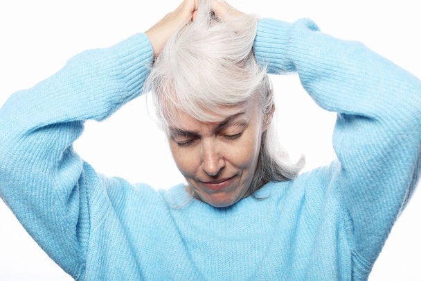 Lifestyle, gezondheid en mensen concept: een portret van een senior dame met hoofdpijn - Foto, afbeelding