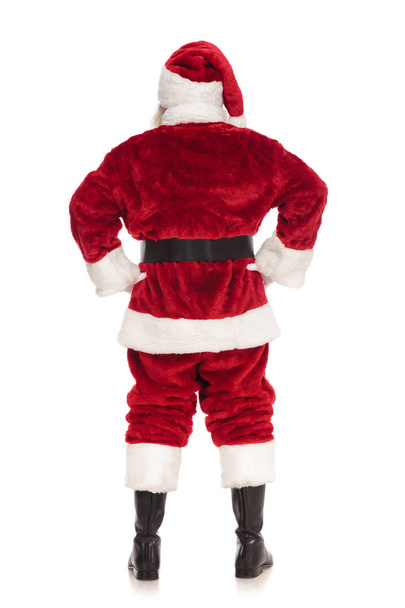 back view of santa claus standing with hands on hips on white background, full body picture - Foto, Imagem