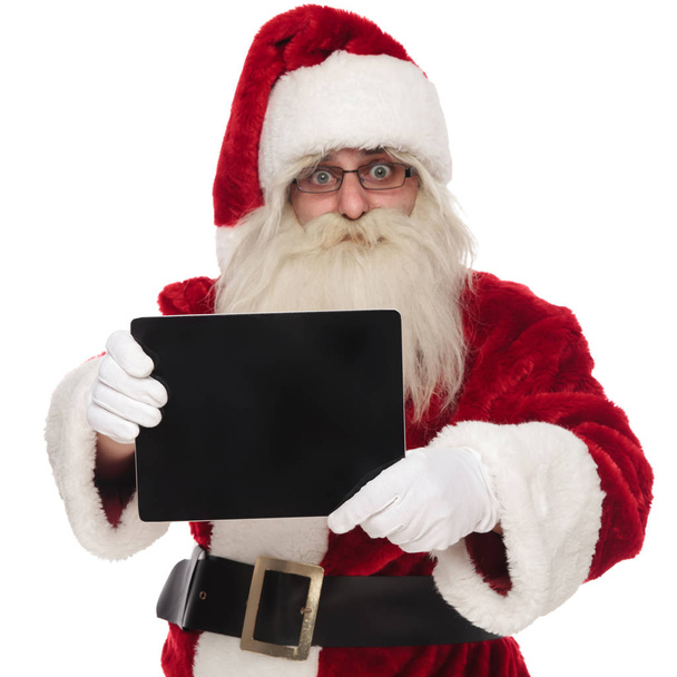 portrait of happy saint nick presenting blank pad screen while standing on white background - Fotoğraf, Görsel
